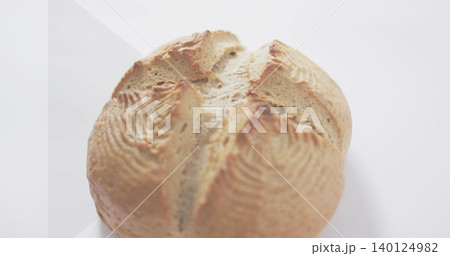 Displaying single round artisan loaf resting on studio table with scored cross and banneton ridges Displaying single round artisan loaf resting on studio table with scored cross and banneton ridges 140124982