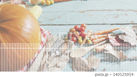 Featuring pumpkin left on rustic blue table with corn, fork, tomatoes, carrots, leaves, copy space 140125054