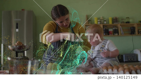 Mixing woman wearing striped apron with baby on kitchen counter cracked eggs and green-blue glow 140125149