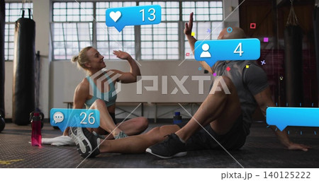 High-fiving woman in sports bra, man in gray tee on gym mat, with overlays, red bottle High-fiving woman in sports bra, man in gray tee on gym mat, with overlays, red bottle 140125222
