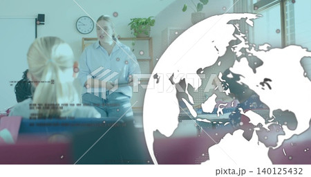 Teaching woman in blue shirt and jeans speaking at front of class, with whiteboard, globe overlay 140125432