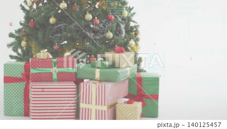 Displaying decorated Christmas tree standing left in white room, showing wrapped gifts with ribbons Displaying decorated Christmas tree standing left in white room, showing wrapped gifts with ribbons 140125457