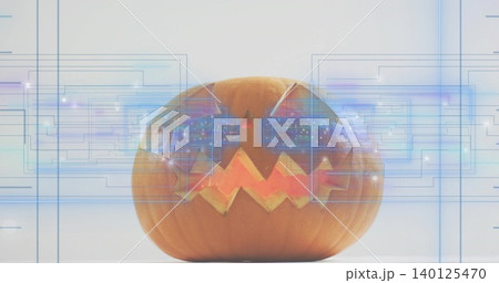 Glowing jack-o-lantern on tabletop, displaying triangular eyes zigzag mouth and blue HUD overlays Glowing jack-o-lantern on tabletop, displaying triangular eyes zigzag mouth and blue HUD overlays 140125470