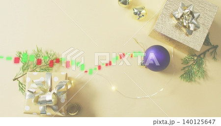 Displaying gold polka-dot gift with metal bow on pale beige table, fairy lights, digital trail 140125647