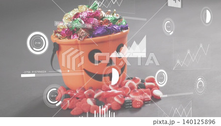 Showing orange jack-o'-lantern bucket with black handle holding foil candies on gray tabletop, HUD Showing orange jack-o'-lantern bucket with black handle holding foil candies on gray tabletop, HUD 140125896