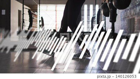 Stepping woman lower body moving across boxing floor, black leggings, gray shoes, wave overlay 140126053
