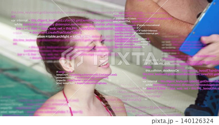 Using blue tablet, adult showing purple code to swimmer in pink swimsuit at tiled pool wall 140126324