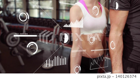 Standing fit female white-sports-bra pink-straps and male dark-tshirt, showing HUD at gym dumbbells Standing fit female white-sports-bra pink-straps and male dark-tshirt, showing HUD at gym dumbbells 140126374