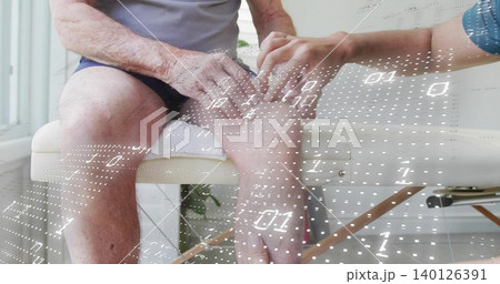 Holding caregiver examining senior's foot on exam bench, senior in gray shirt, binary mesh overlay 140126391