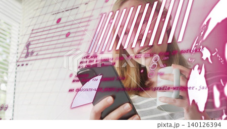 Smiling woman wearing striped top holding smartphone and white mug in home office, pink overlay Smiling woman wearing striped top holding smartphone and white mug in home office, pink overlay 140126394