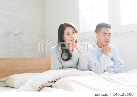起きてベッドの上で会話をする夫婦 起きてベッドの上で会話をする夫婦 140126500