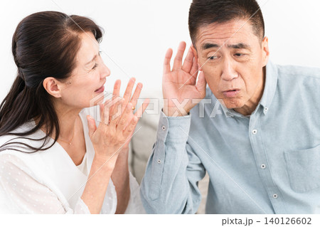 補聴器を付けた熟年男性と喜ぶ女性 補聴器を付けた熟年男性と喜ぶ女性 140126602