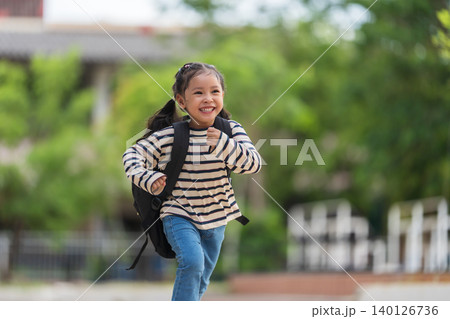 Cheerful student with backpack running happily on her way home from school 140126736