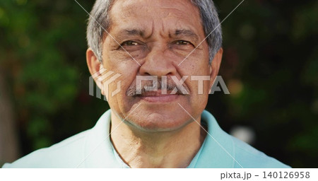 Capturing senior Hispanic man wearing light turquoise polo shirt in garden, showing facial texture 140126958