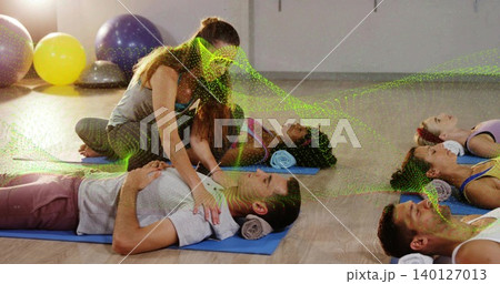 Kneeling instructor in gray tank placing hands on male chest in studio with green dotted overlay Kneeling instructor in gray tank placing hands on male chest in studio with green dotted overlay 140127013