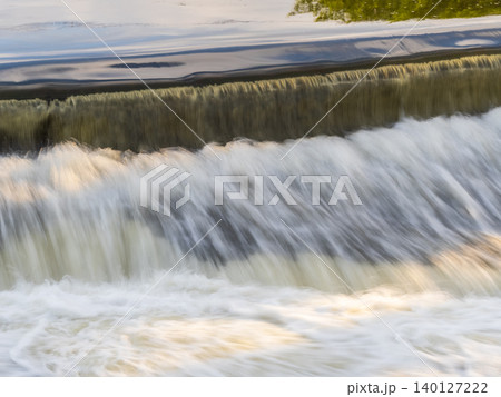 A small flat cascade in a calm river A small flat cascade in a calm river 140127222