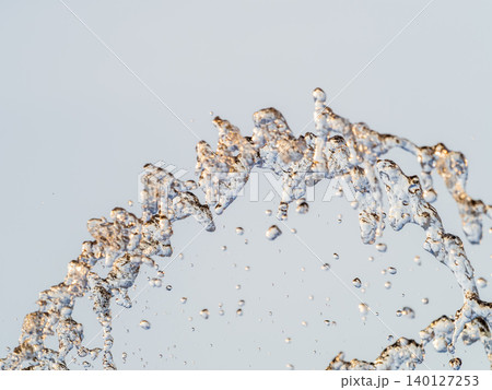Splashes and jets of water against light background. Splashes and jets of water against light background. 140127253