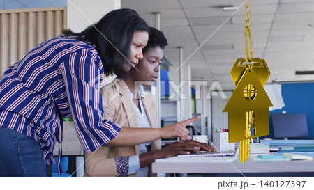 Two professionals are collaborating at desk in flat design business office, featuring gold keychain 140127397