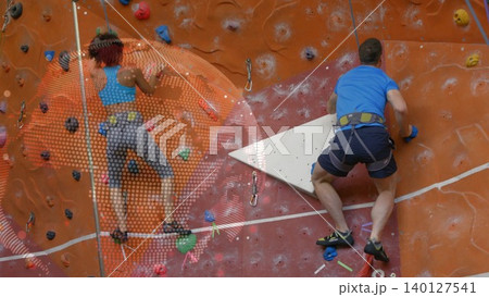 Climbing partners are scaling flat design gym wall for fitness using harnesses and handholds 140127541