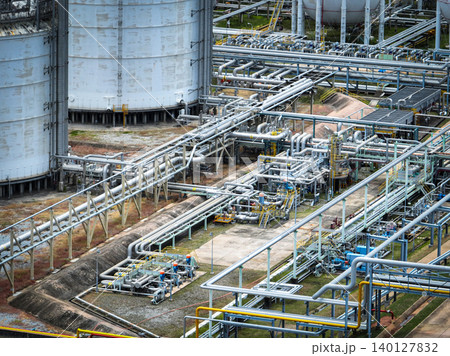 Industrial oil refinery and petrochemical plant with extensive steel pipelines and gas storage tanks. Infrastructure for the energy and fuel. Oil and gas refinery plant. Network of pipes and tanks. Industrial oil refinery and petrochemical plant with extensive steel pipelines and gas storage tanks. Infrastructure for the energy and fuel. Oil and gas refinery plant. Network of pipes and tanks. 140127832