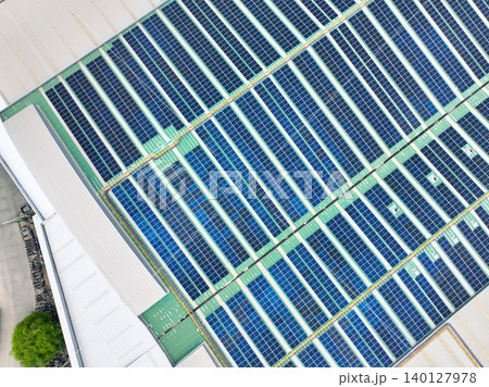 Solar panels on industrial factory rooftop. Renewable energy. Sustainable manufacturing. Green technology. Rooftop solar power. Commercial buildings with efficient renewable energy infrastructure. Solar panels on industrial factory rooftop. Renewable energy. Sustainable manufacturing. Green technology. Rooftop solar power. Commercial buildings with efficient renewable energy infrastructure. 140127978