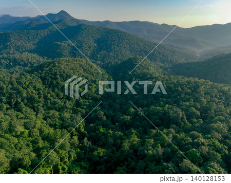 Aerial drone view of dense green forest mountain capture CO2. Carbon neutrality and net zero emissions concept for environmental sustainability and corporate responsibility. Biodiversity conservation. Aerial drone view of dense green forest mountain capture CO2. Carbon neutrality and net zero emissions concept for environmental sustainability and corporate responsibility. Biodiversity conservation. 140128153