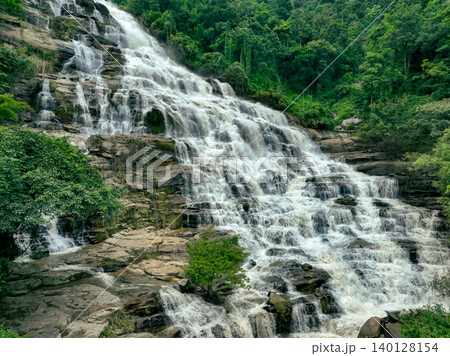 Aerial view of a waterfall in a lush tropical green forest in Doi Inthanon National Park, Chiang Mai, Thailand. This nature landscape showcases water sustainability and scenic travel destinations. 140128154