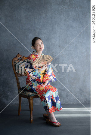 浴衣姿で扇子を持つ椅子に座る日本人女性の和風ビューティーポートレート 浴衣姿で扇子を持つ椅子に座る日本人女性の和風ビューティーポートレート 140128926