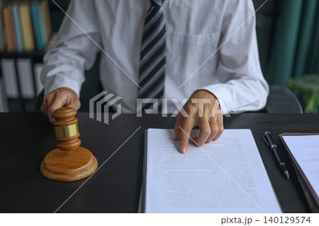 Lawyer Reviewing Contract and Documents with Gavel on Desk. Lawyer Reviewing Contract and Documents with Gavel on Desk. 140129574