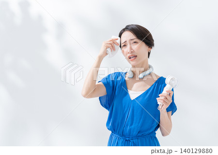 夏にアイスリングとハンディ扇風機を使う女性 夏にアイスリングとハンディ扇風機を使う女性 140129880