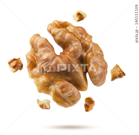 Walnut kernel and pieces flying close up on a white. Isolated Walnut kernel and pieces flying close up on a white. Isolated 140131109
