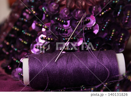 Spool of Purple Thread on Beaded Fabric Spool of Purple Thread on Beaded Fabric 140131826