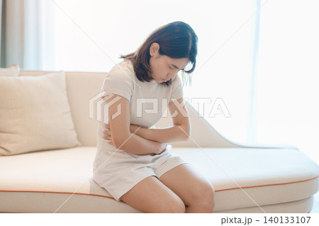 woman having abdomen ache due to Stomach pain, digestion with constipation or Diarrhea from food poisoning, female problem and Endometriosis, Hysterectomy, Stomachache and Menstrual on sofa at home woman having abdomen ache due to Stomach pain, digestion with constipation or Diarrhea from food poisoning, female problem and Endometriosis, Hysterectomy, Stomachache and Menstrual on sofa at home 140133107
