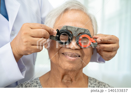 Asian senior woman wearing ophthalmic vision eye test and using optical trial frame. Asian senior woman wearing ophthalmic vision eye test and using optical trial frame. 140133837