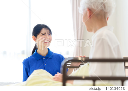 介護施設で会話をするシニアと介護士 介護施設で会話をするシニアと介護士 140134028