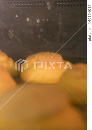 オーブンで焼成中のクッキーシュークリーム生地をガラス越しに撮影した様子 140134053