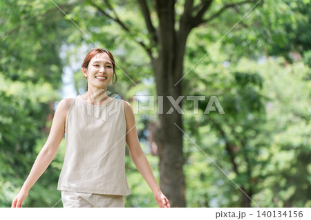 公園の木の下にいる若いアジア人女性（ボタニカルボタニカル,オーガニック,自然,ナチュラル,森林浴） 140134156