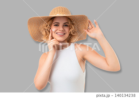 Woman poses with wide-brimmed hat. Summer fashion and confidence concept Woman poses with wide-brimmed hat. Summer fashion and confidence concept 140134238
