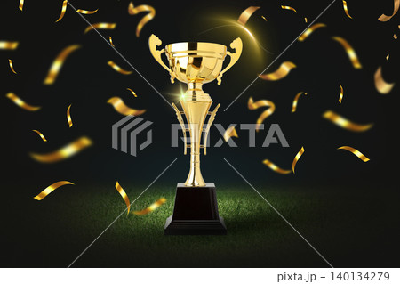 Golden trophy stands on a pedestal with confetti around it 140134279