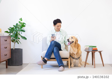 ペット　ゴールデンレトリーバー　リビングで寛ぐ犬と男性 140136102