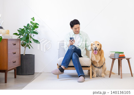 ペット ゴールデンレトリーバー リビングで寛ぐ犬と男性 ペット ゴールデンレトリーバー リビングで寛ぐ犬と男性 140136105