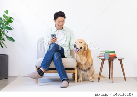 ペット ゴールデンレトリーバー リビングで寛ぐ犬と男性 ペット ゴールデンレトリーバー リビングで寛ぐ犬と男性 140136107