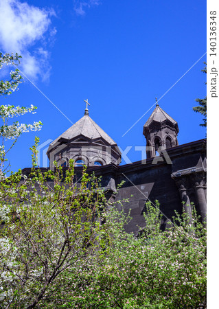 Cathedral of the Holy Mother of God towers peek through blooming greenery under sunny sky Cathedral of the Holy Mother of God towers peek through blooming greenery under sunny sky 140136348