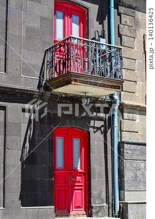 Two red doors, one on balcony, one at ground level Two red doors, one on balcony, one at ground level 140136425