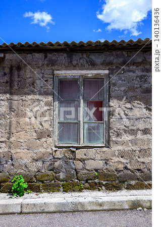 Weathered stone house with single window Weathered stone house with single window 140136436