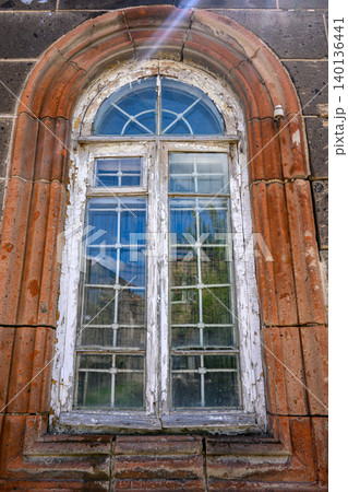 Weathered arched window in rustic brick building Weathered arched window in rustic brick building 140136441