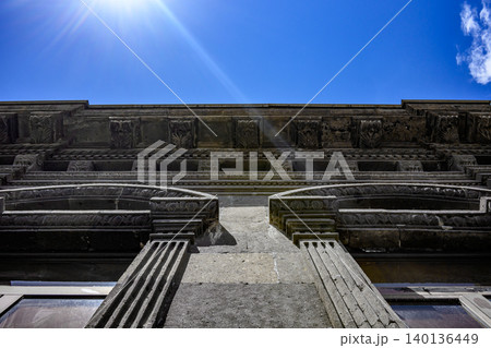 Old stone building facade with arched windows and decorative cornice 140136449