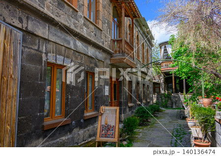 Stone houses with wooden balconies and windows line narrow alley 140136474