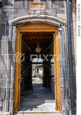 Historic stone entrance with wooden door, lantern, and view into courtyard Historic stone entrance with wooden door, lantern, and view into courtyard 140136478