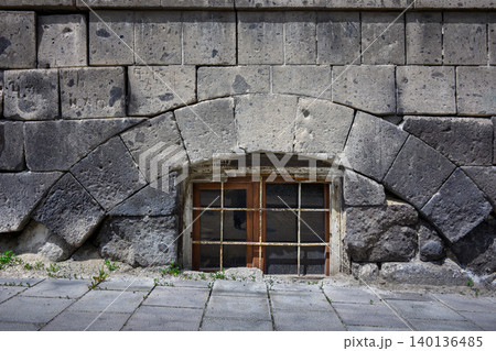 Old stone structure with wooden window under curved arch Old stone structure with wooden window under curved arch 140136485